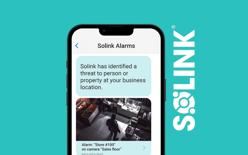 A smartphone screen displays a notification from Solink Alarms about a potential threat at a business location, with an image of a person in a store. Solink logo is visible on a teal background.