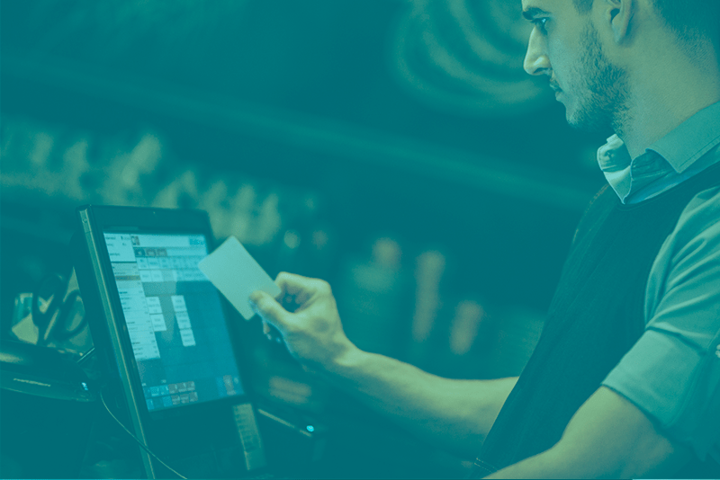 A man is using a tablet to make a payment.